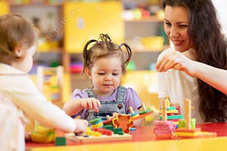 Kids play with shapes and colorful wooden puzzle in a montessori classroom