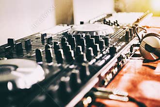 DJ playing music at mixer closeup and mixes the track in the nightclub