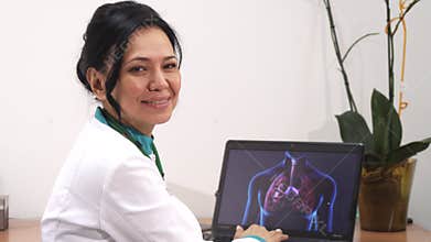 Mature female doctor examining lungs scan on her laptop at the clinic