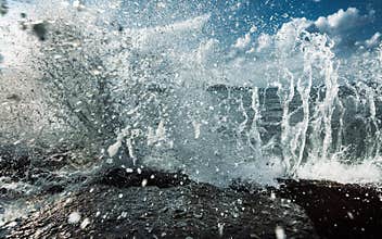 Large Waves Crash into Rock Tide pools, Throwing Foamy White Seawater Spray Into The Air In Storm