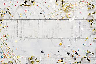 Bright festive carnival background with hats, streamers, confetti and balloons on white background