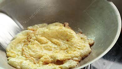 Frying omelet in a pan with hot oil