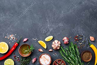 Ingredients for cooking. Herbs and spices on black stone table top view. Food background.
