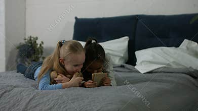 Excited multi ethnic kids watching video on phone