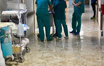 Consult among surgeons and nurses in hospital corridors among a group