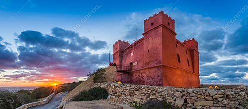 Il-Mellieha, Malta - Tourists watching sunset at St Agatha`s Red Tower with beautiful sky