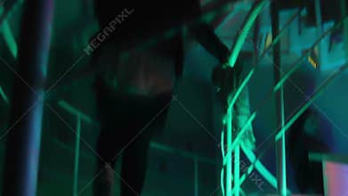 Women and men walking up and down the stairway. Night club atmosphere. Weekend