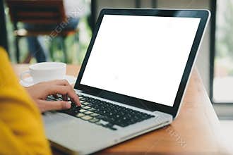 Woman hands typing laptop computer with blank screen on table in coffee shop. Blank laptop screen mock up for display of design.