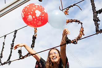 Young woman holding balloons having fun