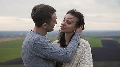 Romantic couple in embracess and kisses stand on the top of rock