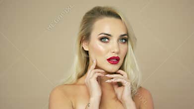 Blonde woman touching face