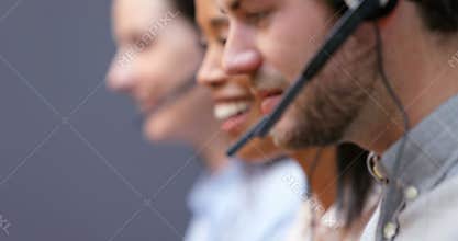 Smiling customer service executives talking on headset at desk 4k