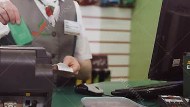 Woman Cashier Checks Bonus on Card in Station Shop