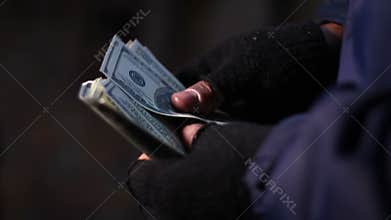 Hands of bank robber or drug dealer counting money, income from illegal acts