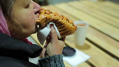 Junk food. Plump woman eating fatty hot dog and drinking hot tea. Overweight