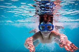 Boy in mask dive in swimming pool