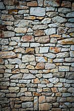 Stone wall background. Vignetted borders. Vertical photo
