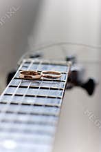 Two wedding rings are on guitar stripes
