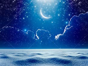 Crescent moon in dark blue night starry sky above snowy field, b