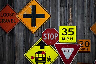 Collection of various road signs on rustic wooden wall