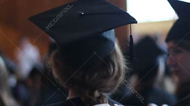 Mother braiding daughter's hair. Preparations for graduation ceremony at college
