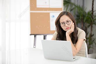 Asian woman thinking hard concerned about online problem.