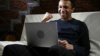African Man Excited for Successful Online Shopping