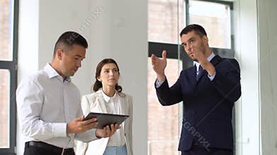 Realtor showing office to customers with tablet pc