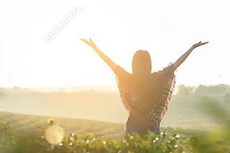 Lifestyle traveler women happy feeling good relax and freedom facing on the natural tea farm in the sunrise morning,