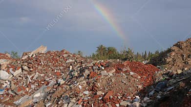 Spilled garbage and colorful rainbow at blue sky. Environmental pollution. Ecological problem. Concept ecology