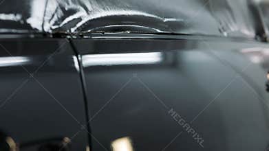 Car hood after painting in a cars spray booth. Auto vehicle cherry color hood. Parts of car in cars spray booth.