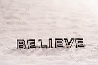 Believe word on white sand