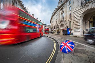 London, England - Iconic red double-decker buses and black taxi on the move on Regent Street