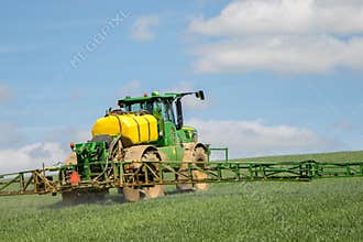 John Deere R4040i sprayer spraying in wheat field