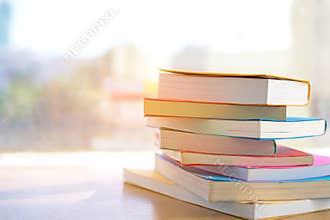 Book stack in the library room for back to school and education on sunny day near window in library.