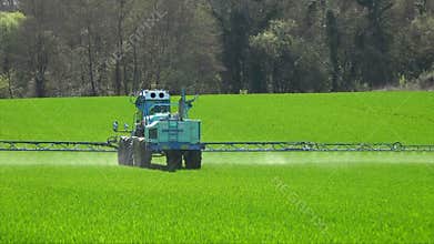 Agriculture fertilizer working on farming field, agriculture machinery working on cultivated field and spraying