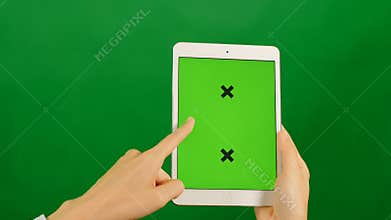 Businesswoman using a blank green screen tablet on green background.