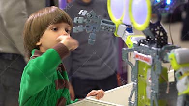 Robot and child. Boy looking for dancing robot. Kid boy watching robot dance. Boy look at robotic technology at