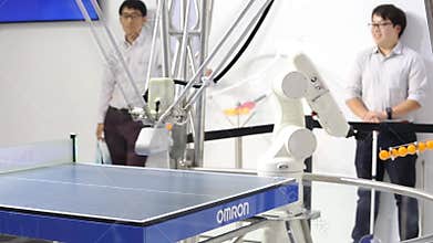 Robot playing ping-pong table tennis on Omron stand on Messe fair in Hannover, Germany