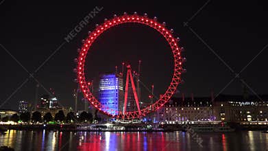 Timelapse of London Eye`s colorful lights by night reflected in River Thames