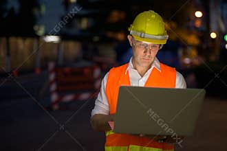 Mature man construction worker at the construction site in the c