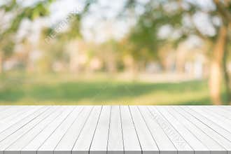 White wood table top on green blurred background,space for montage product