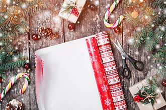 Christmas composition with xmas wrapping, Fir branches, gifts, pine cones, red decorations on wooden background.