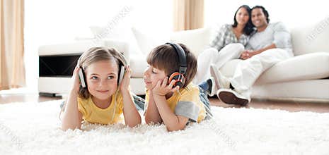 Siblings playing on the floor with headphones