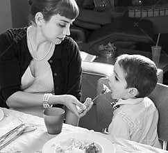 Mom feeds her son on Thanksgiving turkey