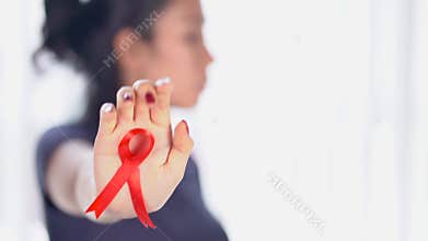 Woman showing world AIDS day awareness ribbon