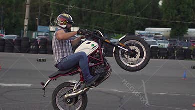 A professional motorcyclist rides a bike and does various extreme tricks. Slow motion 120fps