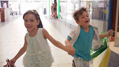 Joyful children with shopping bags run to make purchases at discounts during sales on black Friday