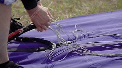 Close up shot of a skydiving instructor packing, preparing equipment for the jumping, parachute straps.