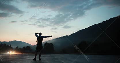 Despait. Silhouette of a man hitchhiking on the road in the night darkness while cars pass him away
